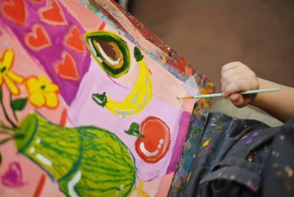 a child is painting a picture on a canvas